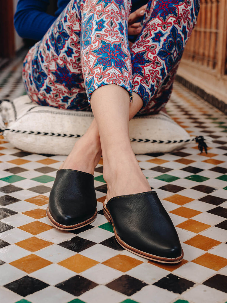 Bohemia-leather-mules-black-on-model-with-Moroccan-tiles-and-floor-cushion