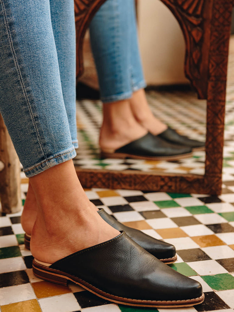 Bohemia-leather-mules-black-on-model-with-Moroccan-tiles-and-mirror