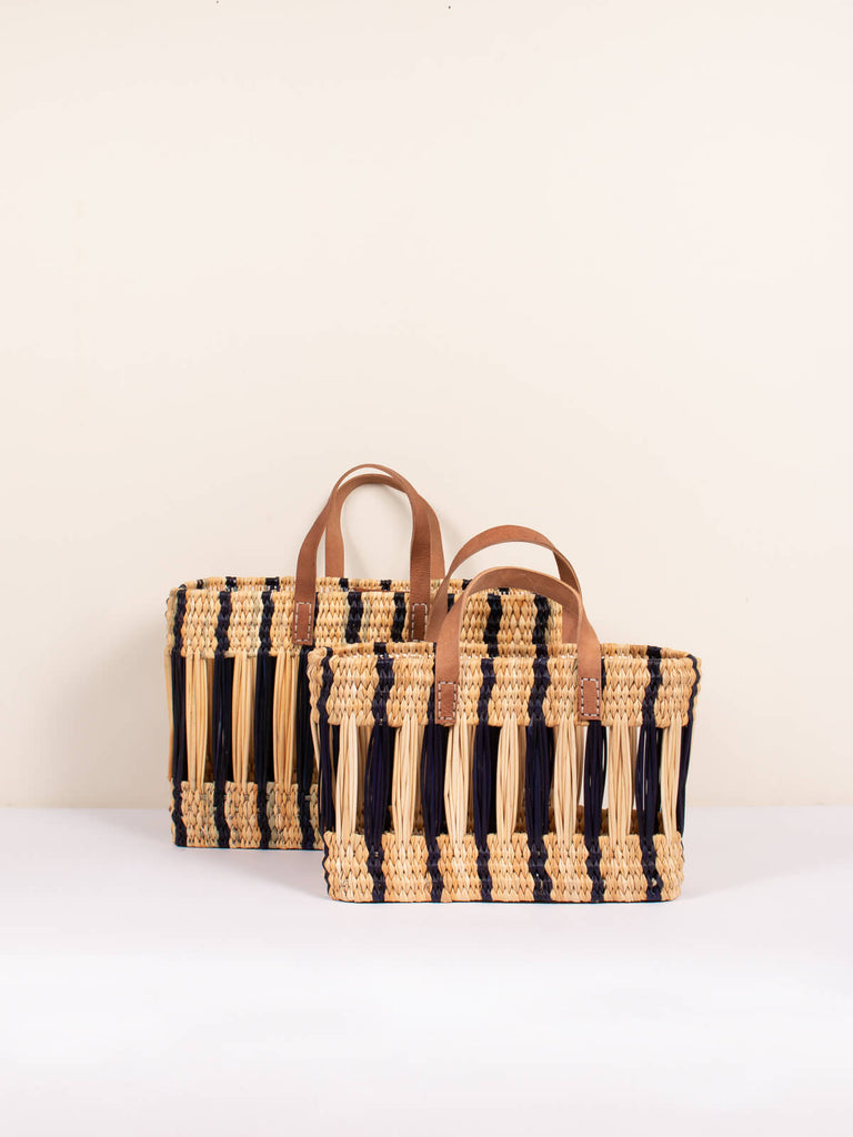 Two sizes of decorative woven reed basket bags with indigo stripe design and short leather handles