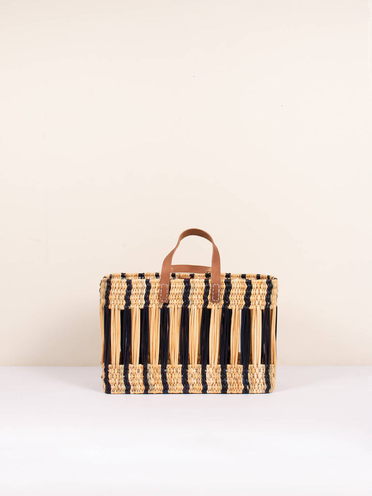 Decorative woven reed basket bag with leather handles and indigo stripe design