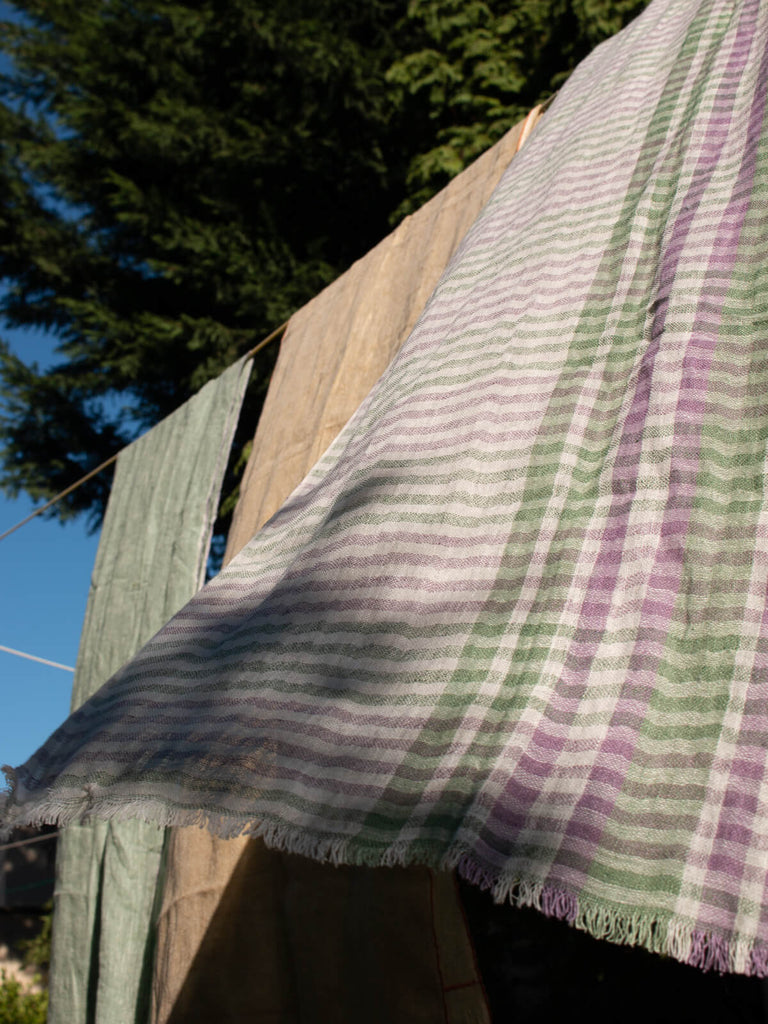 Linen scarf in sage and lilac check hanging on a washing line