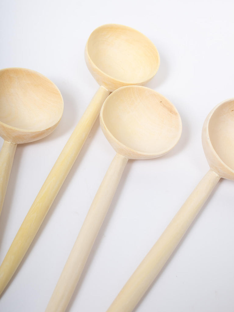 A group of medium lemon wood spoons on a white background