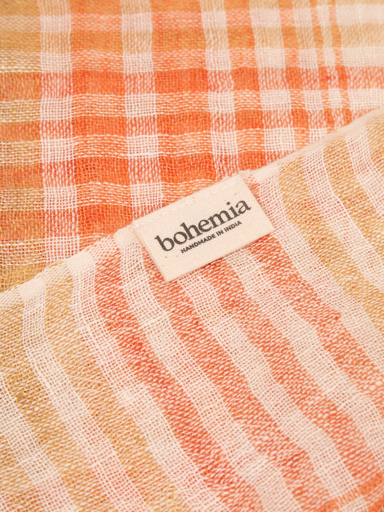 Close up of the checked linen scarf in mustard and orange showing handmade in India Bohemia label