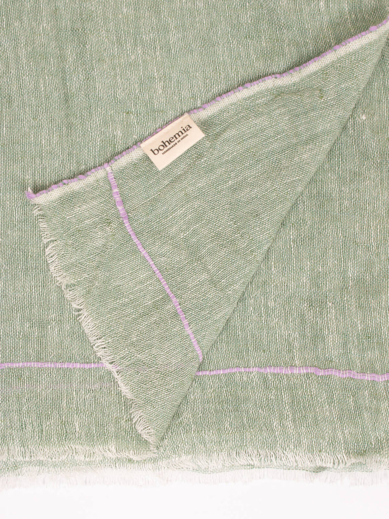 Close up of the subtle lilac stitching around the edge of the sage linen scarf
