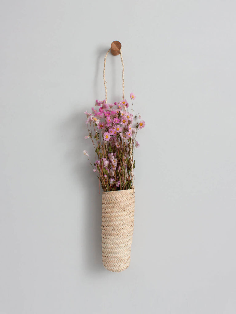 Long Hanging Basket with pink flowers hanging on a wooden hook