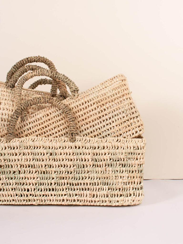 Three sizes of long open weave storage baskets stacked together