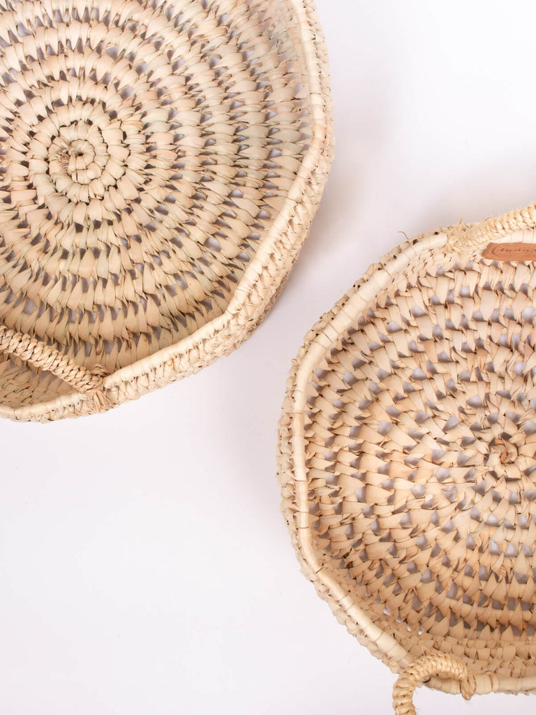 Two natural woven baskets showing the round open weave pattern from above