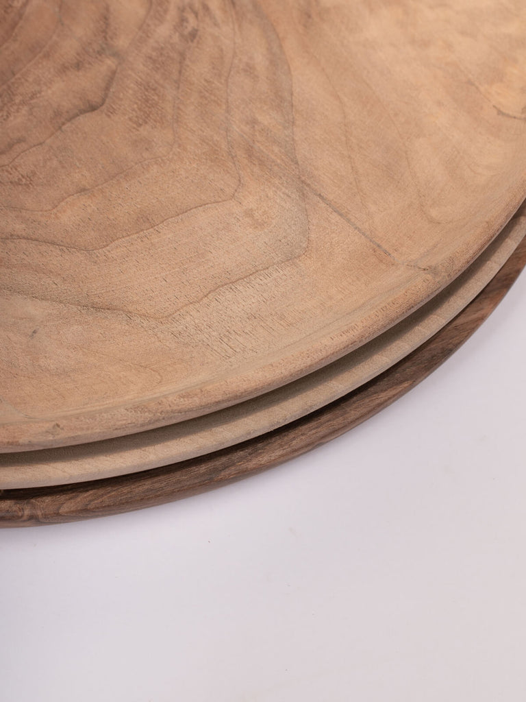 A stack of three Walnut Wood Plates by Bohemia Design