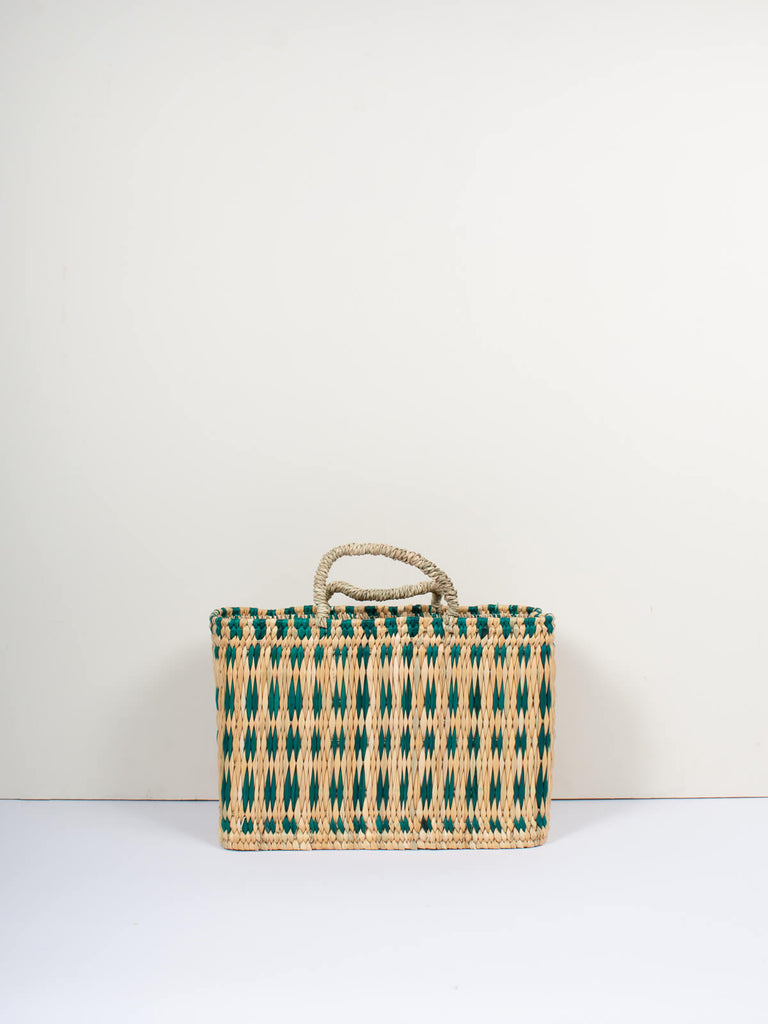 Medium natural woven reed basket bag with handles and a skillfully weaved green pattern by Bohemia Design