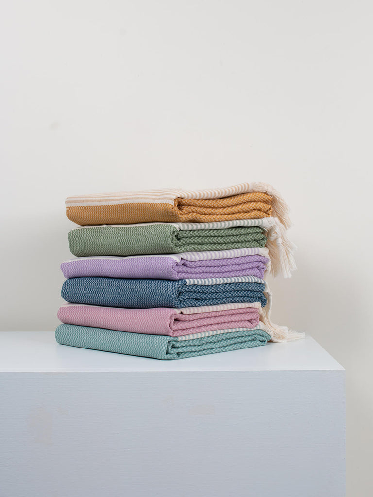 Pile of folded colourful Amalfi hammam towels by Bohemia Design