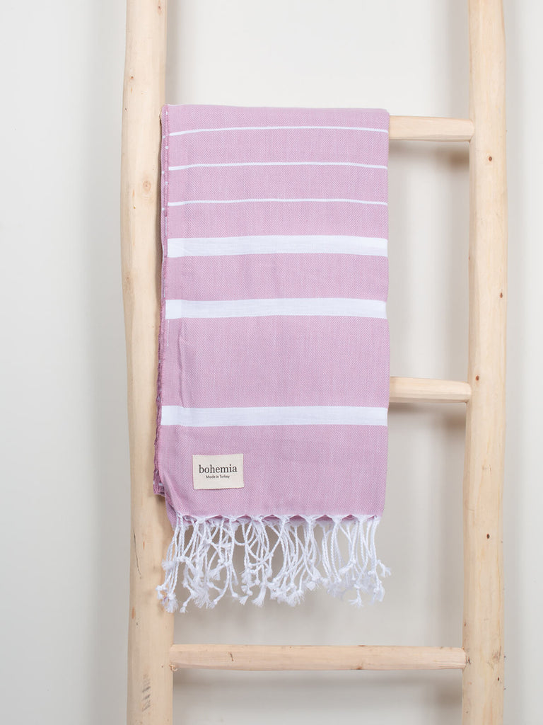 Ibiza Summer Hammam Towel in vintage pink stripe pattern by Bohemia Design hanging on a wooden ladder