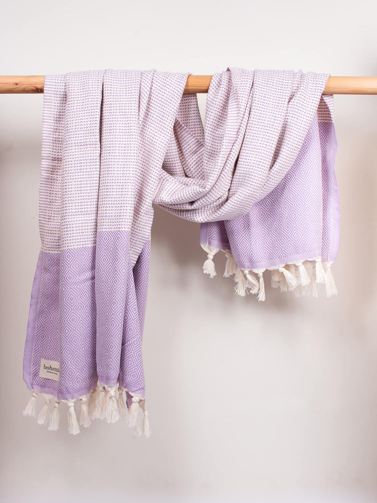 Nordic Dot Hammam Towel in lilac diamond pattern by Bohemia Design hanging on a wooden rod
