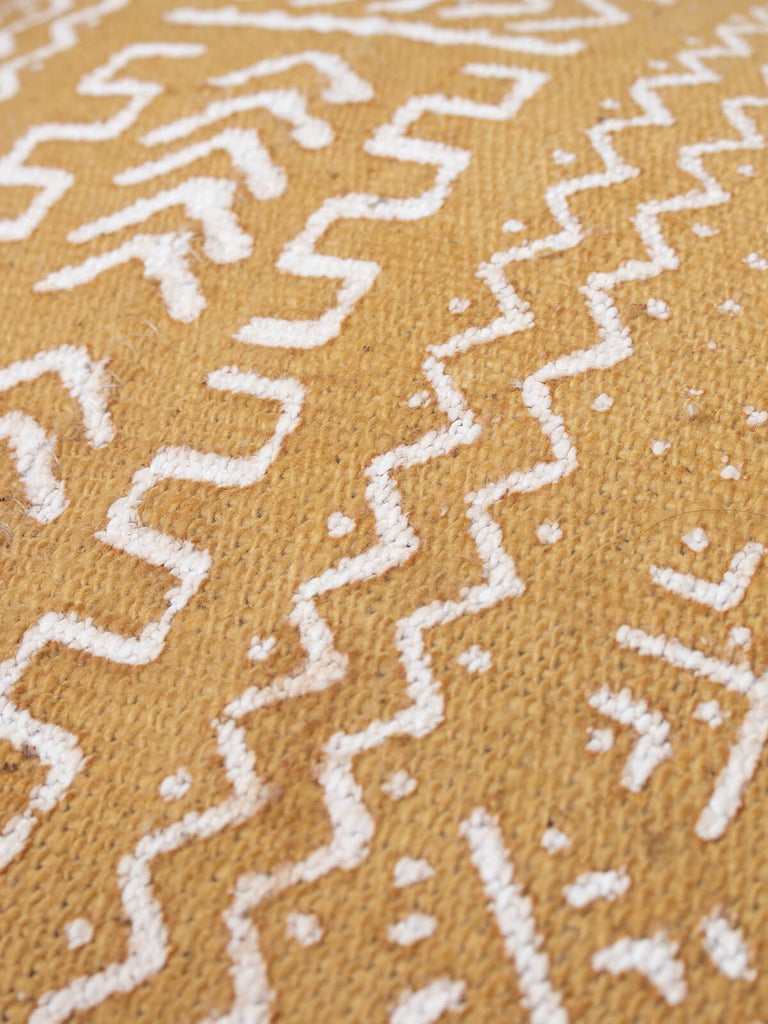 Detail of Saffron coloured cushion with mudcloth patterns by Bohemia Design