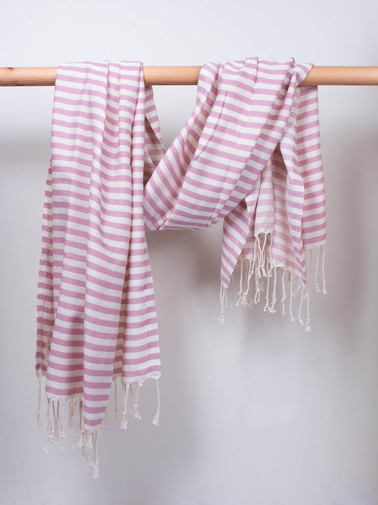 Striped Sorrento Hammam Towel in vintage pink stripe by Bohemia Design hanging from a wooden rod